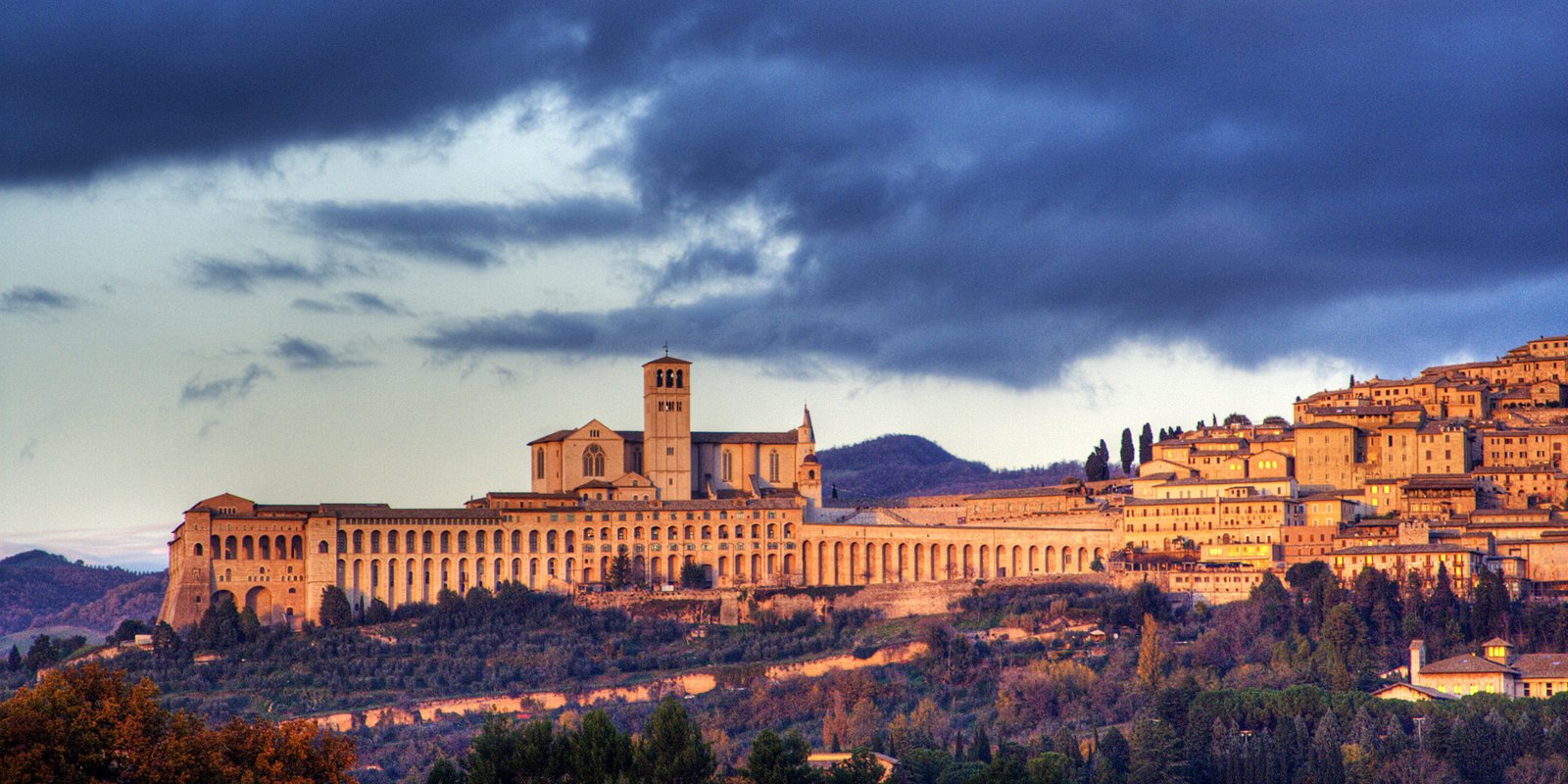 Il profilo di Assisi e la Basilica di San Francesco visti dalla campagna al tramonto