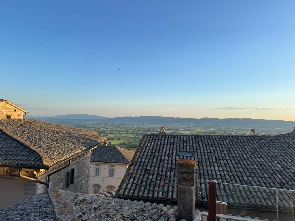 Vista dalla terrazza di Luce sui tetti in coppi del centro storico di Assisi e sulla Valle Umbra