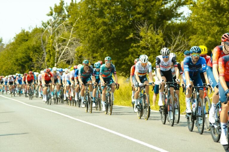 Gruppo di ciclisti professionisti in corsa, peloton compatto su strada