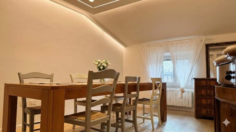 Soggiorno di Riflesso ad Assisi con tavolo da pranzo in legno, sedie impagliate e illuminazione indiretta a soffitto