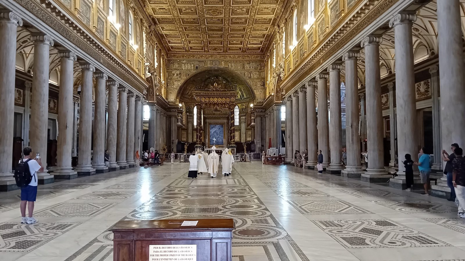 Interno della Basilica di Santa Maria Maggiore a Roma: la navata paleocristiana con le colonne, il soffitto a cassettoni dorato e il mosaico absidale sullo sfondo