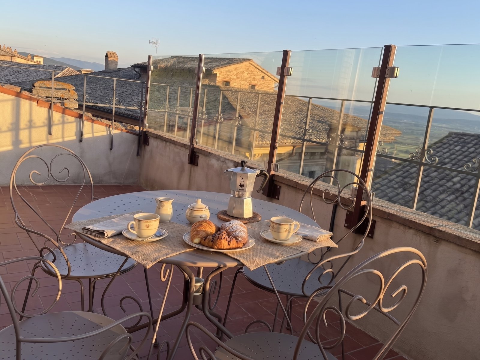 Terrazza panoramica dell'attico Luce ad Assisi con tavolo apparecchiato per la colazione e vista sulla Valle Umbra